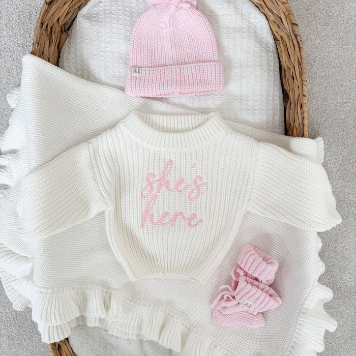 White chunky knitted jumper, pink script logo, ribbed crew neck, ruffled cuffs