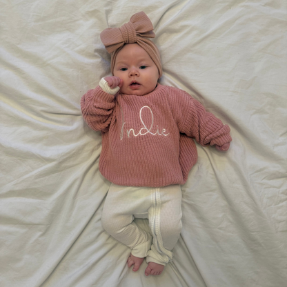 Dusty pink knit jumper with 'Indie' script on chest and crew neckline