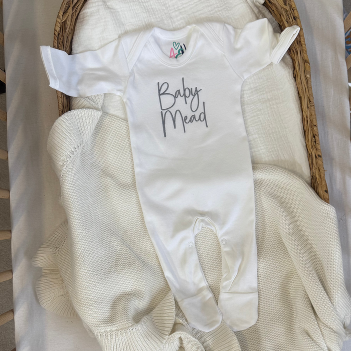 White baby personalised sleepsuit with script name and press-stud leg openings