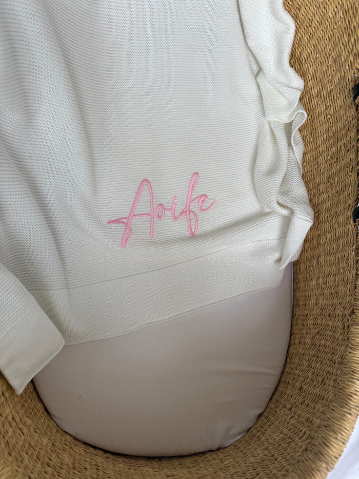 White baby blanket with pink “Arfie” embroidery, folded edge detail
