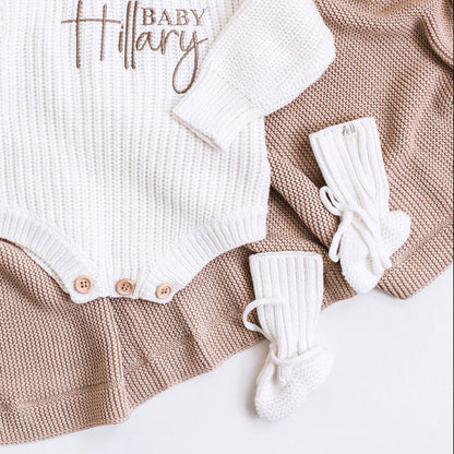 White knitted baby booties with ribbed cuffs and lace ties