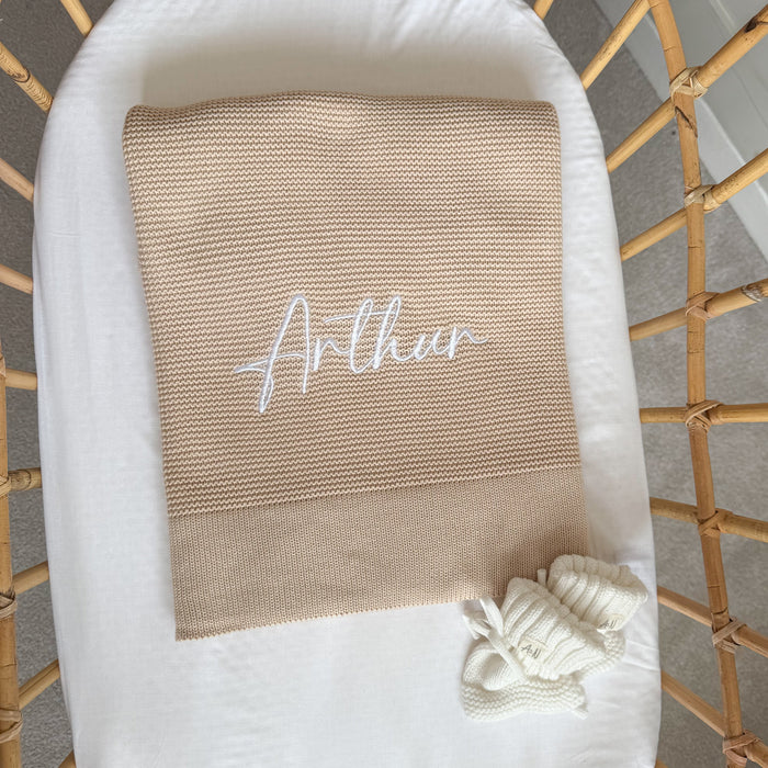 Baby beige knit blanket with embroidered name 'Arthu' and white tied corner trim