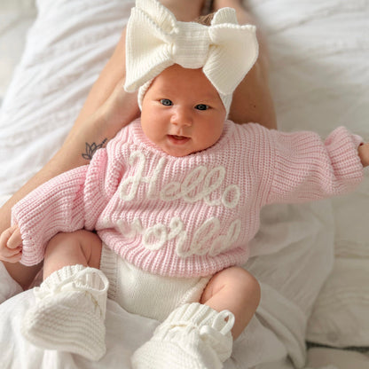 Baby pink chunky knit jumper with "hello world" graphic, ribbed crew neck and cuffs