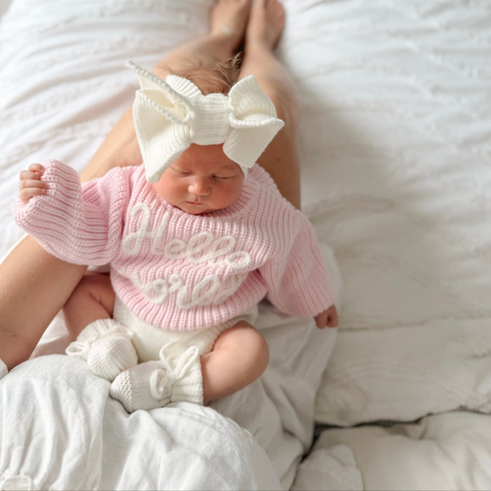 Baby pink chunky knit jumper with "hello world" text, ribbed neckline and sleeve cuffs