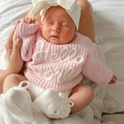 Baby pink chunky knit jumper with "hello world" design, ribbed collar and cuffs