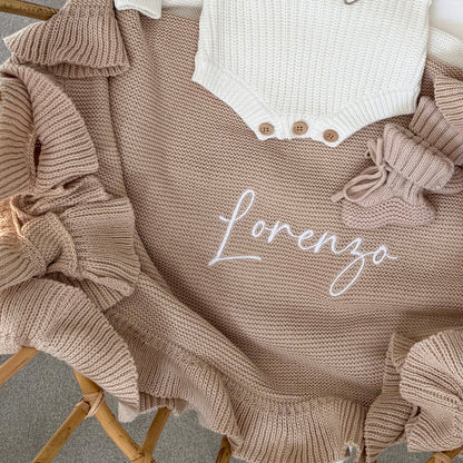 Beige knit blanket close-up with frill edge and 'lorenzo' script
