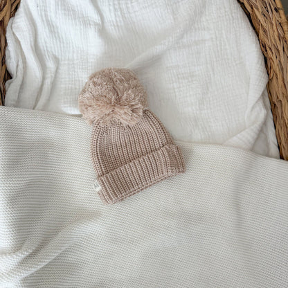 Beige knitted baby beanie with pom-pom and ribbed cuff