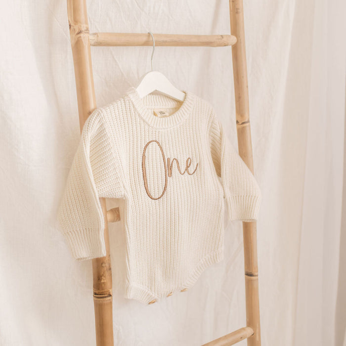 Knitted romper, cream with 'One' script on chest, crew neck, long sleeves