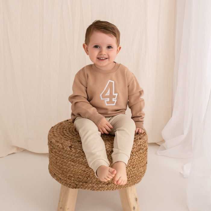 Tan crewneck sweater with embroidered '4' on front, long sleeves