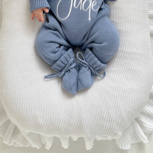 Blue knitted baby booties with tied bow and ribbed cuff