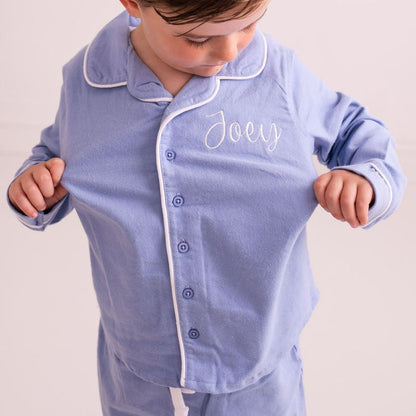 Light blue pajama shirt with stand collar, buttons, and embroidered script