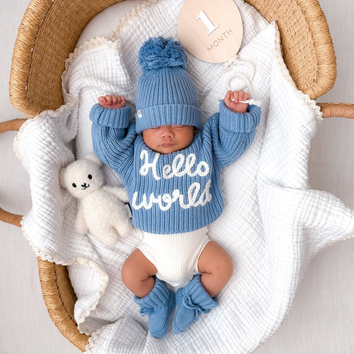 Blue chunky knit baby jumper with 'Hello world' lettering and ribbed neckline