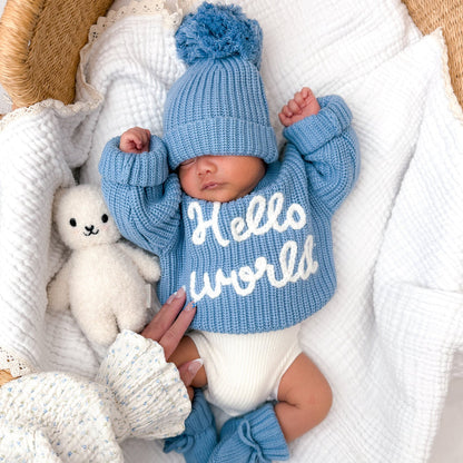 Blue chunky knit baby jumper with ribbed cuffs and 'Hello world' print