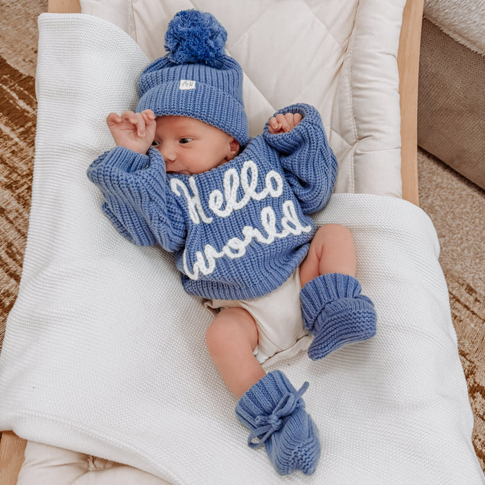 Blue chunky knit baby jumper with “Hello world” lettering, ribbed cuffs