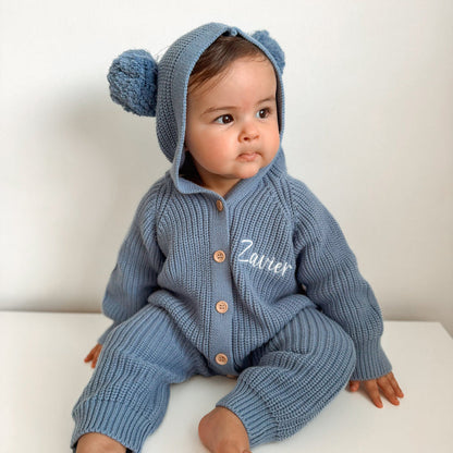Blue knit romper with hood and pom-poms, button front, and 'Ziver' name embroidery