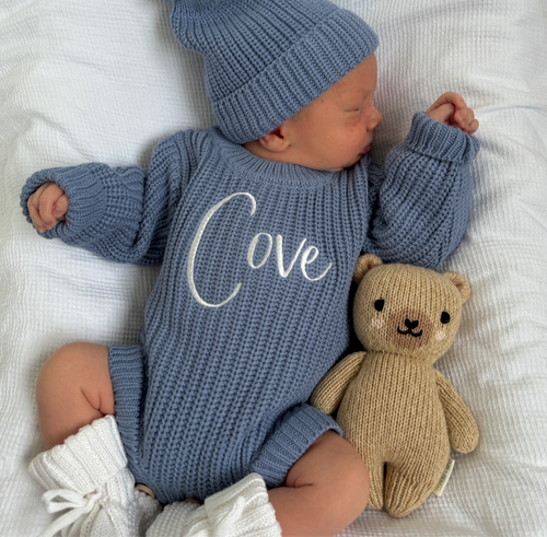 Blue knitted romper with white embroidered “Olive”, long sleeves and cuffs