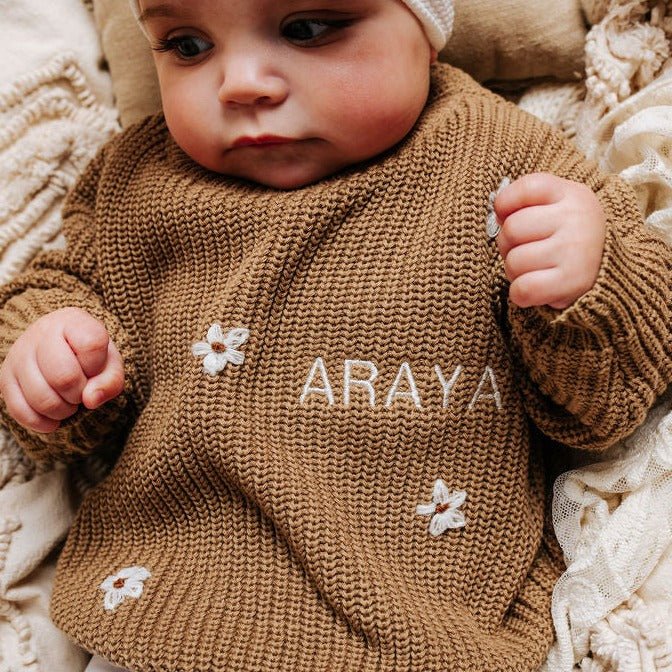 Brown knitted baby jumper with white floral appliqués and 'ARAYA' name embroidery