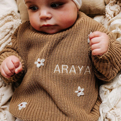 Brown knitted baby jumper with white floral appliqués and 'ARAYA' name embroidery