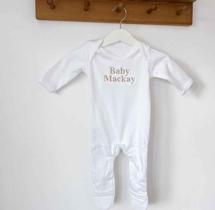 White baby sleepsuit with long sleeves and round neck, 'Baby Mackay' print