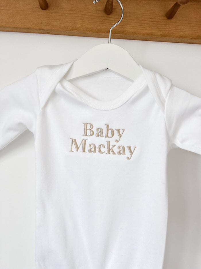White baby sleepsuit neckline and chest print, 'Baby Mackay'