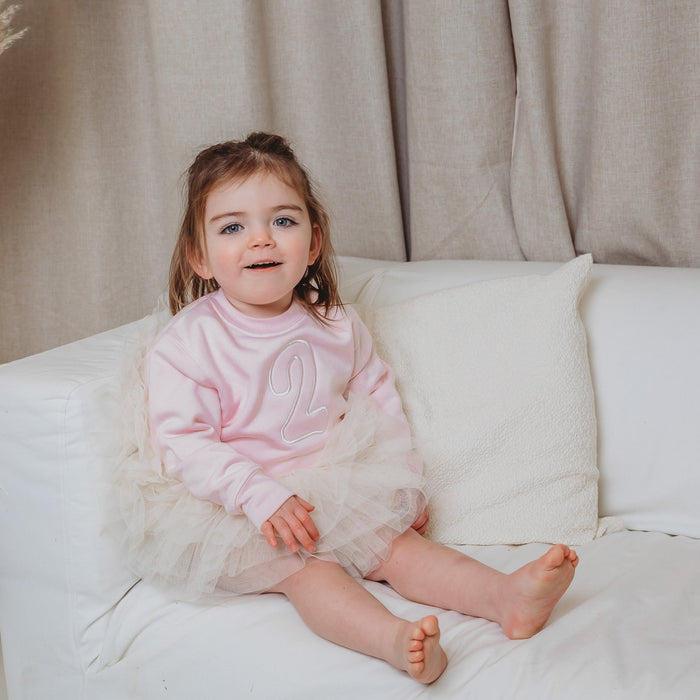 Light pink kids sweater with front embroidered number detail and long sleeves