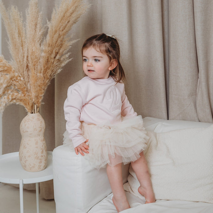 Light pink kids sweater with embroidered number on the front, long sleeves
