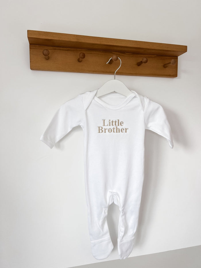 White baby sleepsuit with short sleeves and 'Little Brother' print on the chest