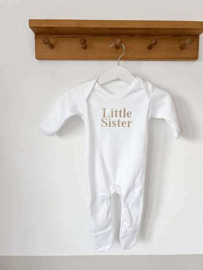White baby sleepsuit with long legs and Little Sister chest print
