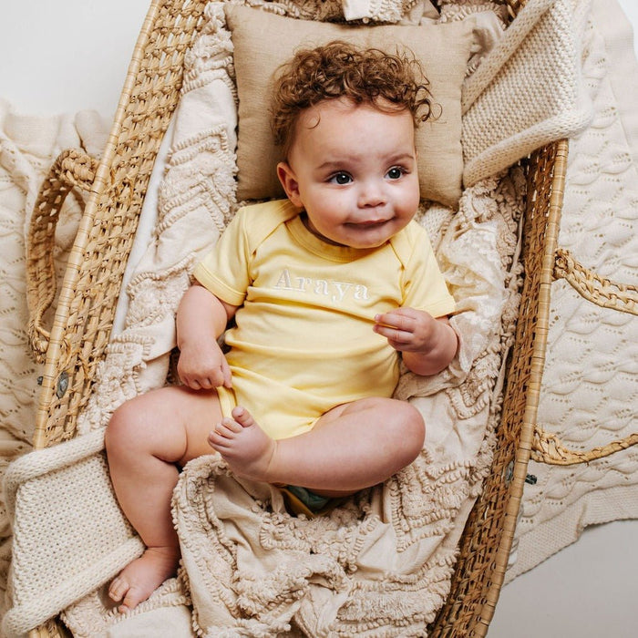 Yellow embroidered baby vest with crew neck and short sleeves