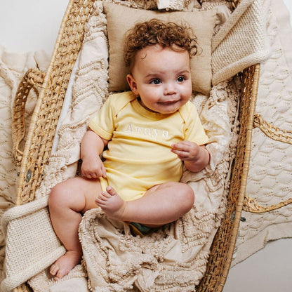 Yellow embroidered baby vest with crew neck and short sleeves