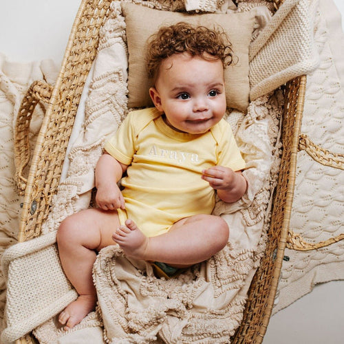 Yellow embroidered baby vest with crew neck and short sleeves