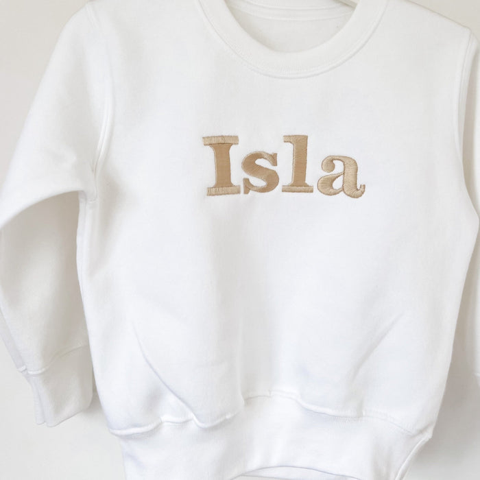 Close-up of white sweatshirt chest print reading “Isla”