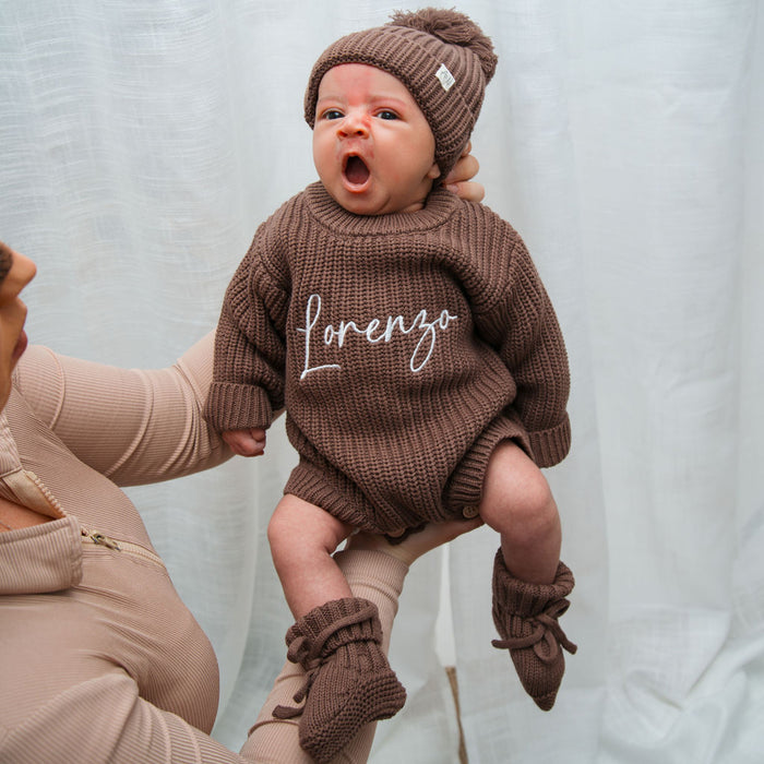 Dark brown knitted baby romper and beanie with pom-pom, 'lorenzo' script on chest
