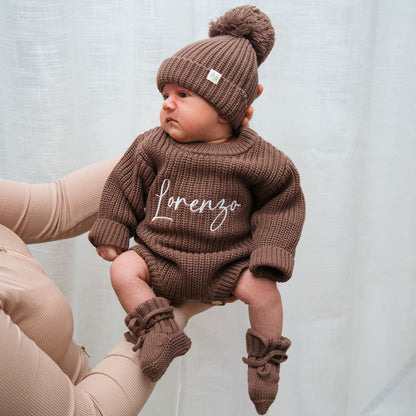 Dark brown knitted romper with matching beanie and pom-pom, 'lorenzo' on front