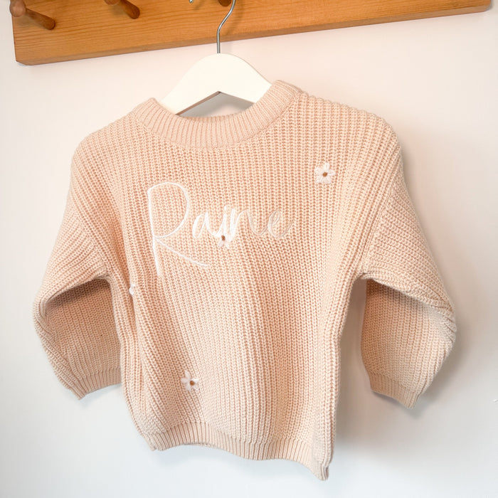 Cream knitted jumper with long sleeves, crew neck, and white script name detail