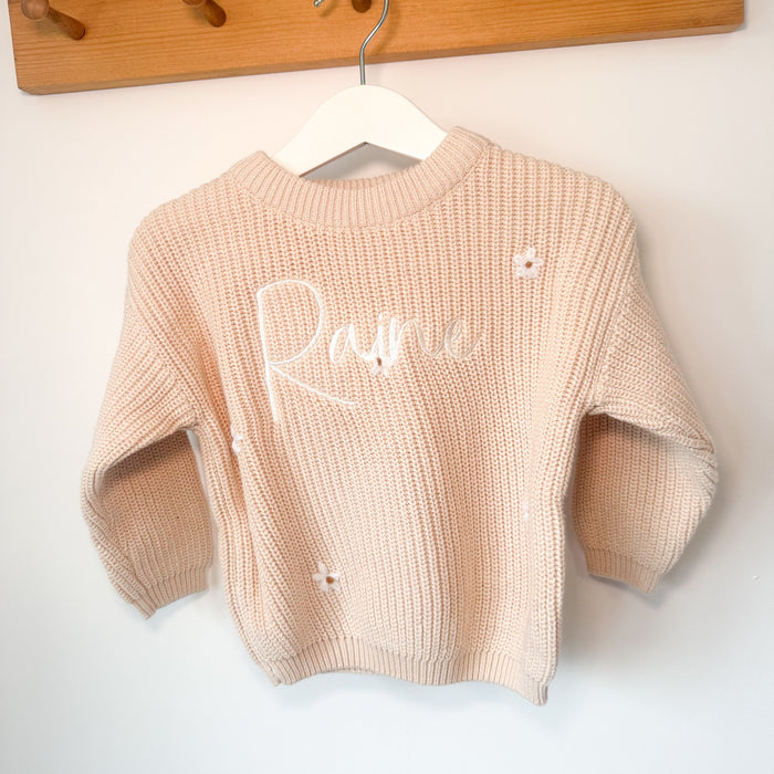 Cream knitted jumper with long sleeves, crew neck, and white script name on front