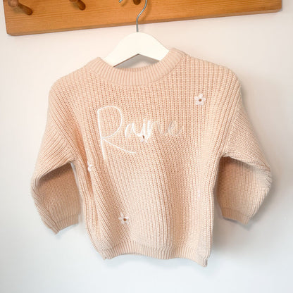 Cream knitted jumper with long sleeves, crew neck, and white script name on front