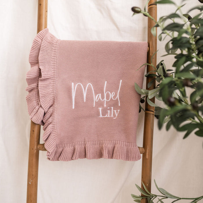 Dusty pink personalised knit blanket with white “Mabel Lily” embroidery and frill trim