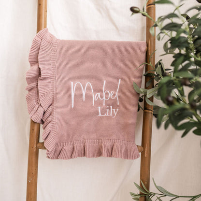 Dusty pink personalised knit blanket with white “Mabel Lily” embroidery and frill trim