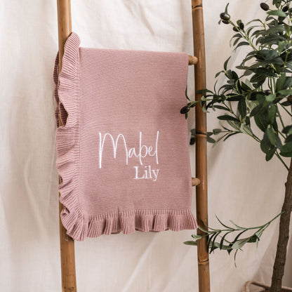 Dusty pink personalised knit blanket with frilled border and “Mabel Lily” text