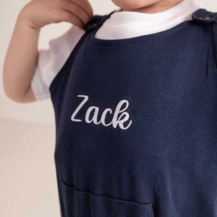 Navy dungarees close-up with embroidered 'Zack' name on the chest