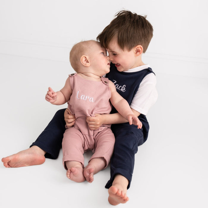 Navy and dusty pink embroidered name dungarees showing 'Zack' and 'Lara'