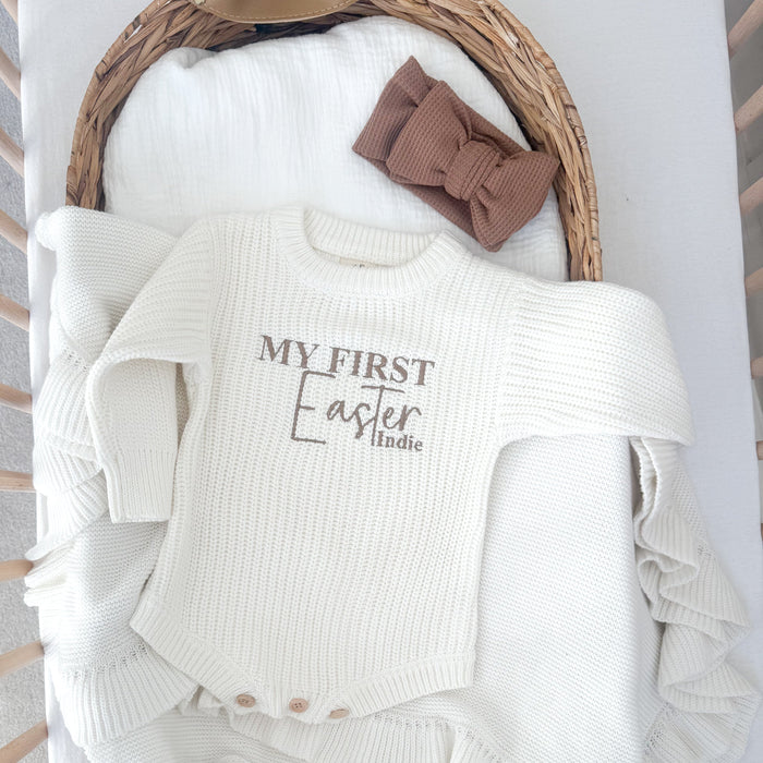 White knitted baby romper with 'My First Easter' and 'Indie' on front