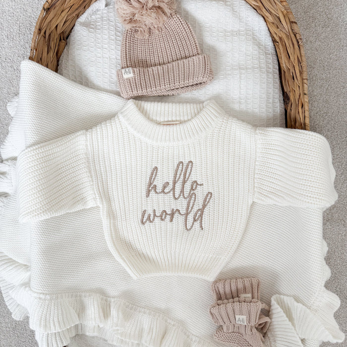 White chunky knit jumper with 'hello world' script and ruffle trim at hem