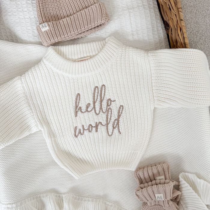 White chunky knit jumper with 'hello world' script on the chest