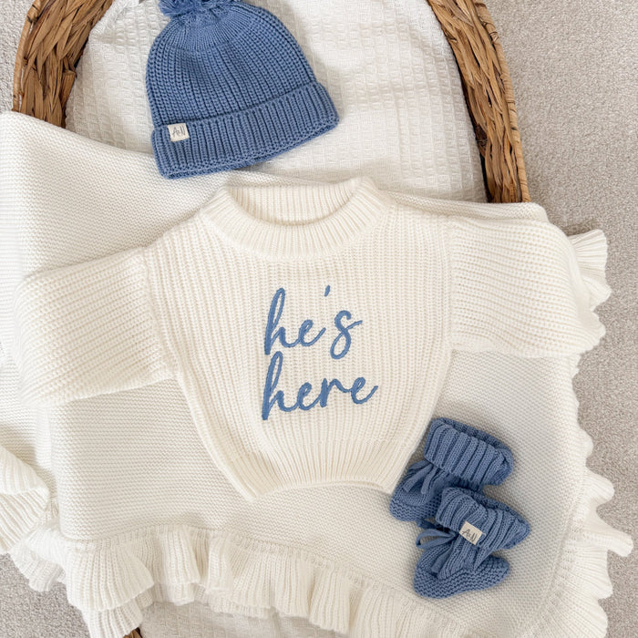 White chunky knit jumper with blue 'he's here' print, textured knit and ruffled trim