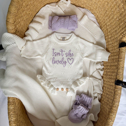 White pointelle knit romper with lavender panel, ruffled sleeves, embroidered heart text