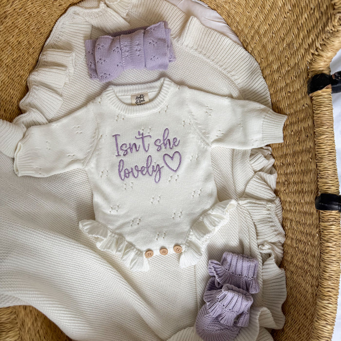 White pointelle romper with lavender top panel, embroidered message, buttoned legs