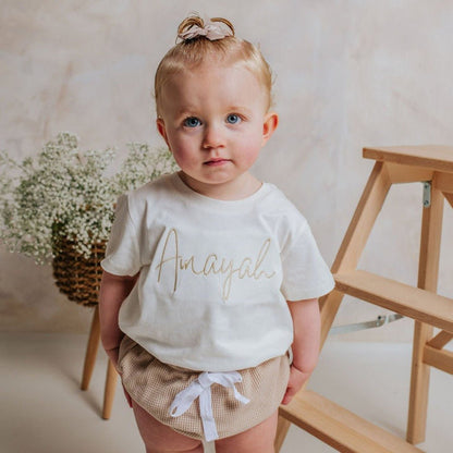 Ivory toddler T-shirt with gold script-name lettering, short sleeves