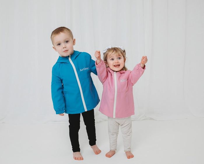 Blue and pink lightweight rain coats with hoods and front zips, elastic cuffs